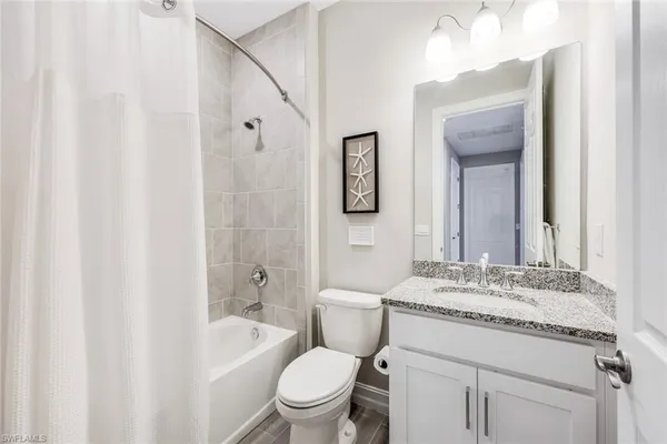 a bathroom with a granite countertop sink toilet a mirror and shower