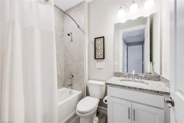 a bathroom with a granite countertop sink toilet a mirror and shower