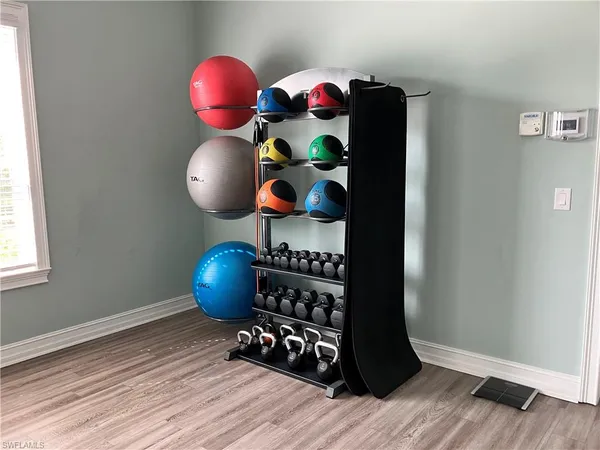 a room with wooden floor and gym equipment