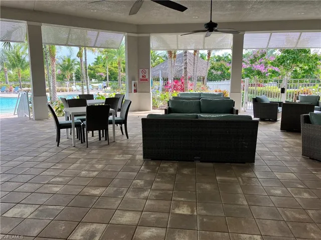 a living room with couches a flat tv screen and a floor to ceiling window with garden view