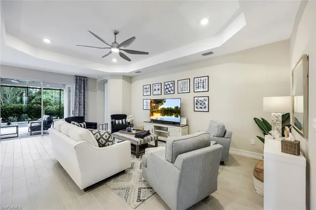 a living room with furniture ceiling fan and a flat screen tv