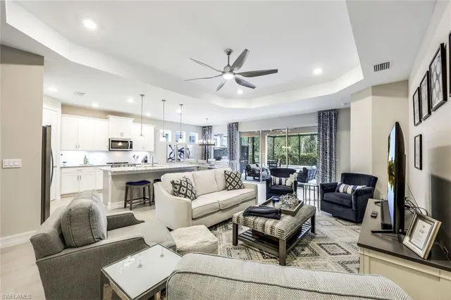 a living room with furniture ceiling fan and a window