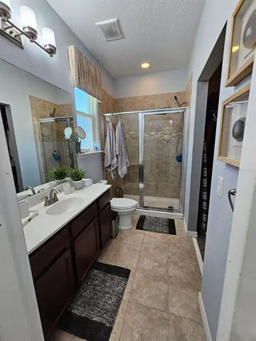 a bathroom with a double vanity sink toilet and shower