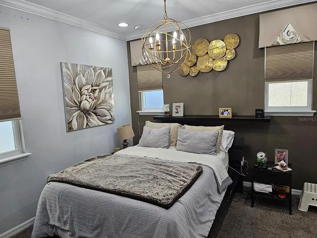 a bedroom with a bed and a chandelier