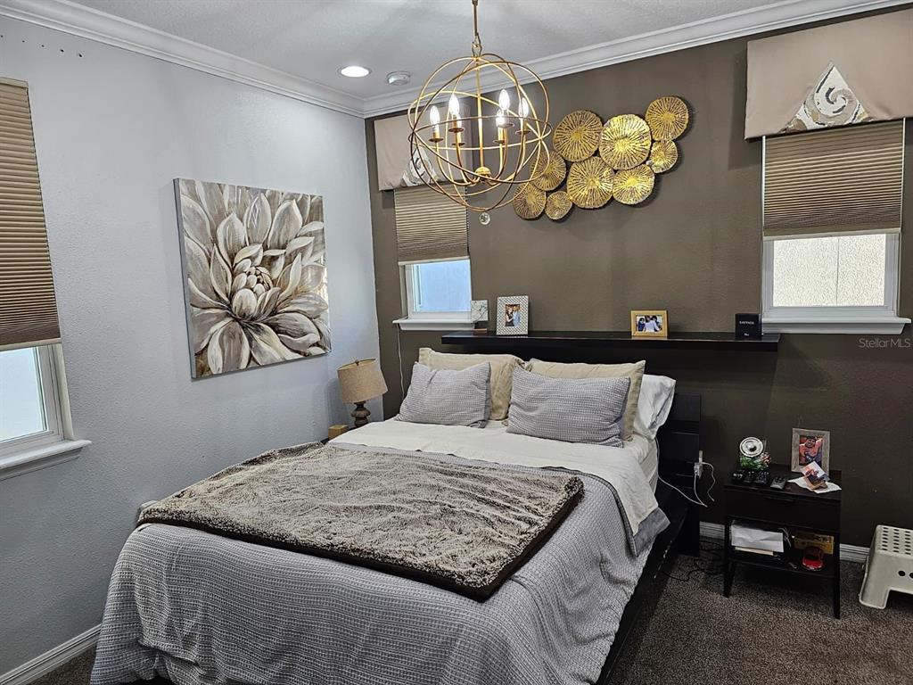 8552 Powder Ridge Trail Windermere, FL 34786 - Photo 19 of 39 a bedroom with a bed and a chandelier