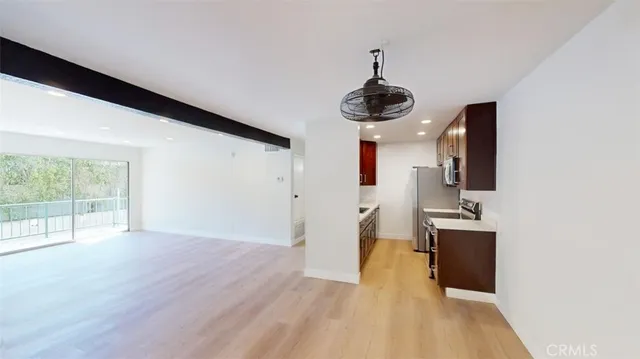 a view of a room with wooden floor and ceiling fan
