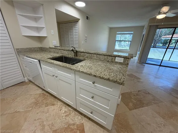 a kitchen with granite countertop white cabinets and stainless steel appliances