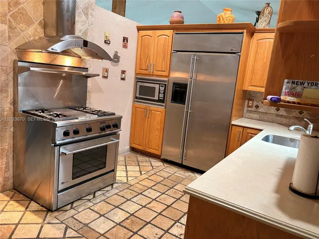 a kitchen with stainless steel appliances and wooden cabinets