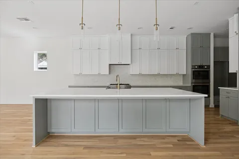 a kitchen with stainless steel appliances granite countertop a sink and dishwasher with white cabinets