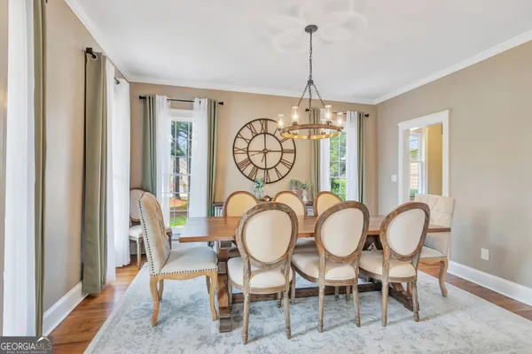 a dining room with furniture a chandelier and wooden floor