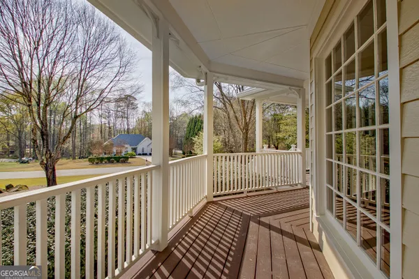 a view of a balcony with wooden floor and fence