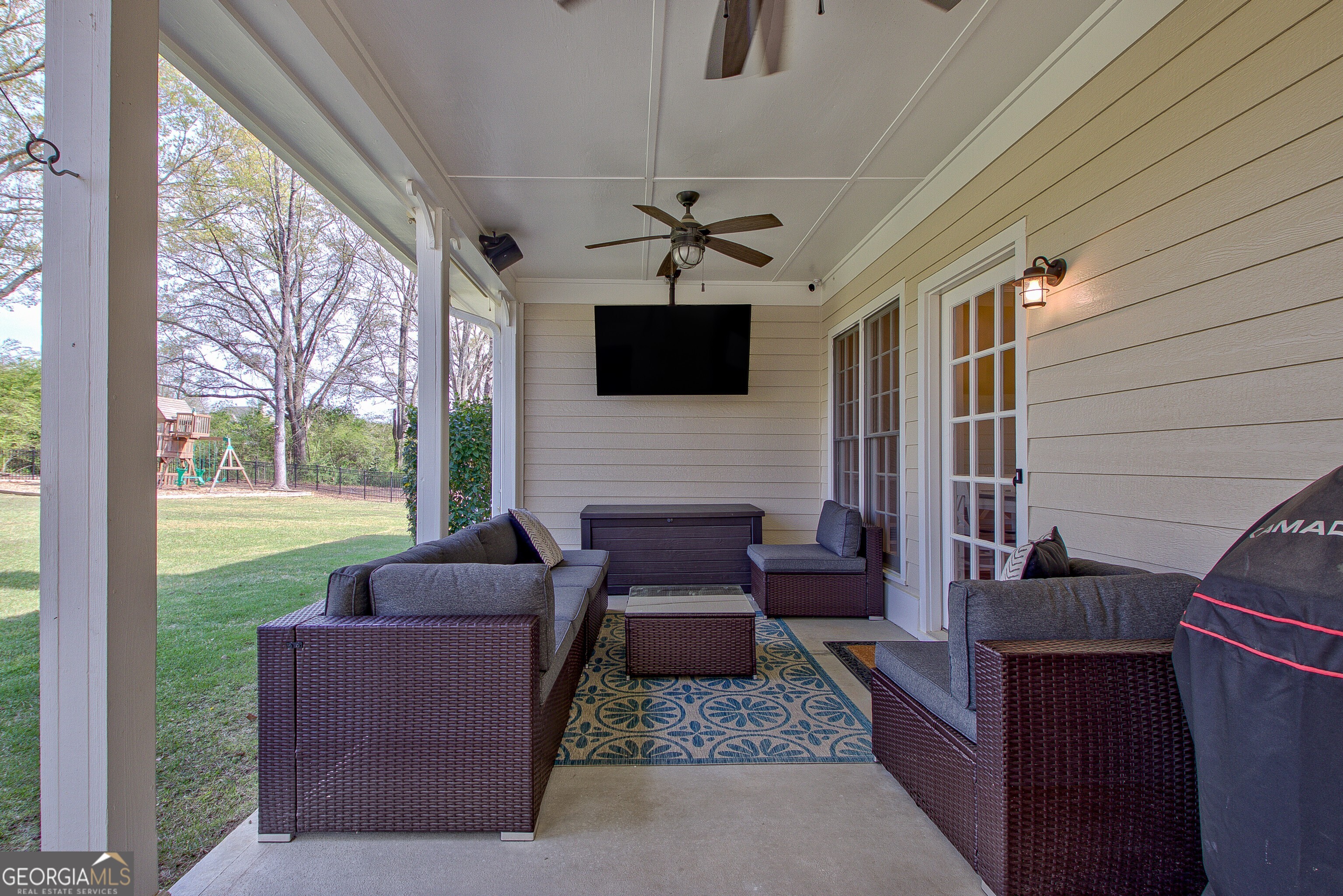 388 Swanson Road Tyrone, GA 30290 - Photo 44 of 62 a living room with furniture a flat screen tv and a floor to ceiling window