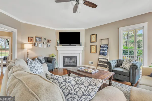 a living room with furniture a ceiling fan and a window