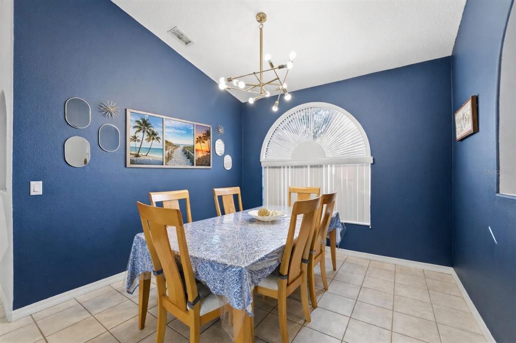 5220 Kirkwood Avenue Spring Hill, FL 34608 - Photo 16 of 67 a view of a dining room with furniture wooden floor and chandelier