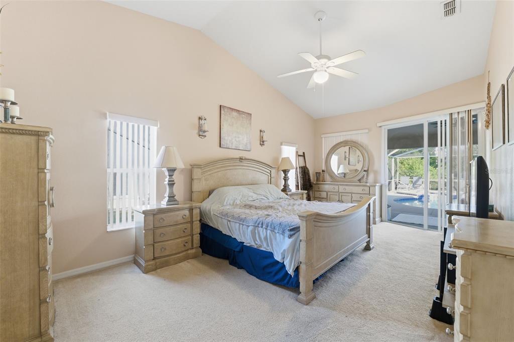 5220 Kirkwood Avenue Spring Hill, FL 34608 - Photo 18 of 67 a bedroom with a bed a mirror and a large window with the outer view