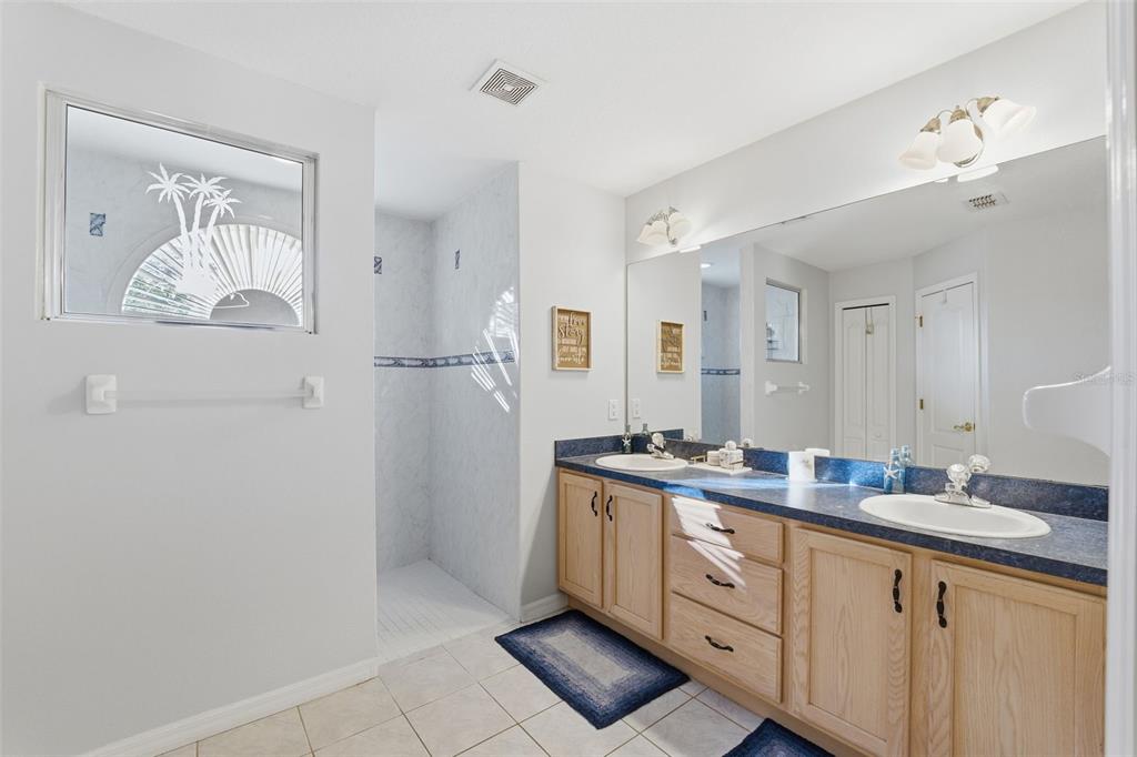 5220 Kirkwood Avenue Spring Hill, FL 34608 - Photo 21 of 67 a spacious bathroom with a granite countertop sink mirror and vanity