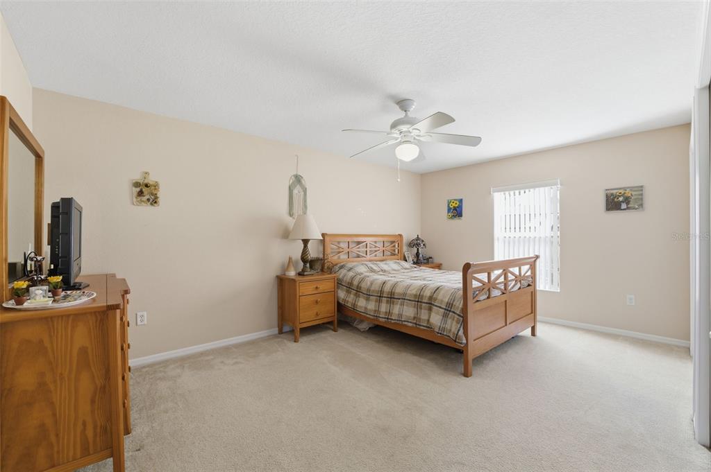 5220 Kirkwood Avenue Spring Hill, FL 34608 - Photo 24 of 67 a bedroom with a white bed and a chandelier