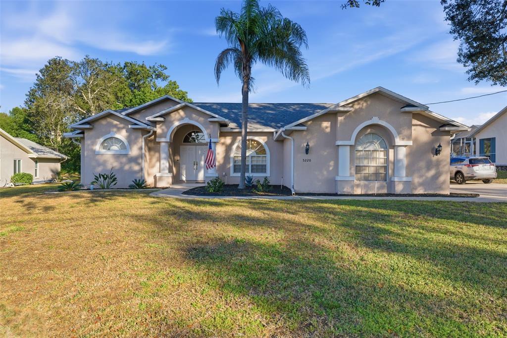 5220 Kirkwood Avenue Spring Hill, FL 34608 - Photo 3 of 67 a front view of a house with a garden and plants