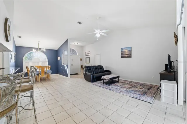 a kitchen with stainless steel appliances granite countertop a sink a stove a refrigerator cabinets and living room view