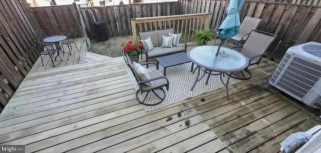 a balcony with wooden floor table and chairs