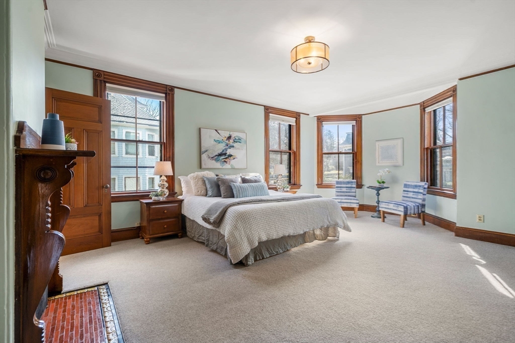 44 Putnam Street Newton, MA 02465 - Photo 18 of 38 a spacious bedroom with a bed and a chandelier