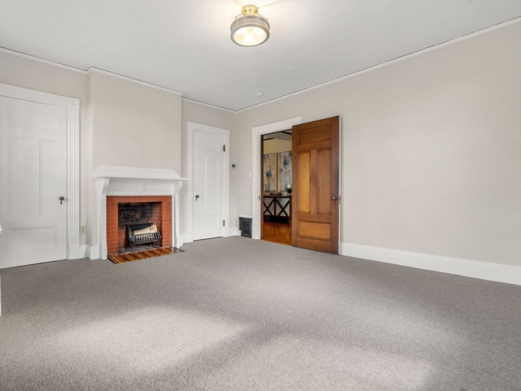 44 Putnam Street Newton, MA 02465 - Photo 24 of 38 a view of an empty room with a fireplace and a window
