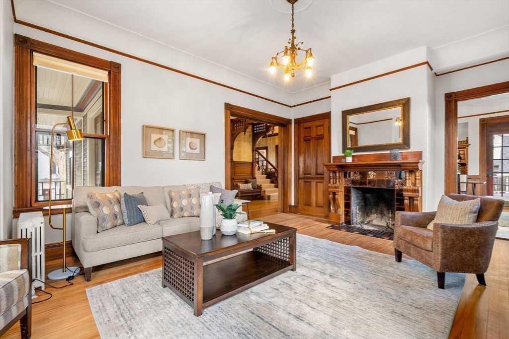 44 Putnam Street Newton, MA 02465 - Photo 5 of 38 a living room with furniture a fireplace and a chandelier