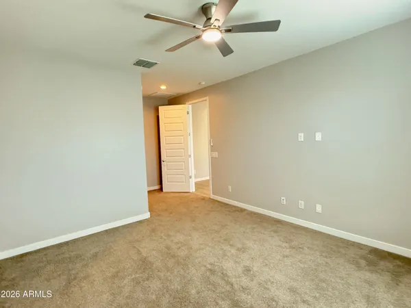 an empty room with closet and a ceiling fan