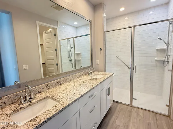 a bathroom with a granite countertop sink mirror and shower