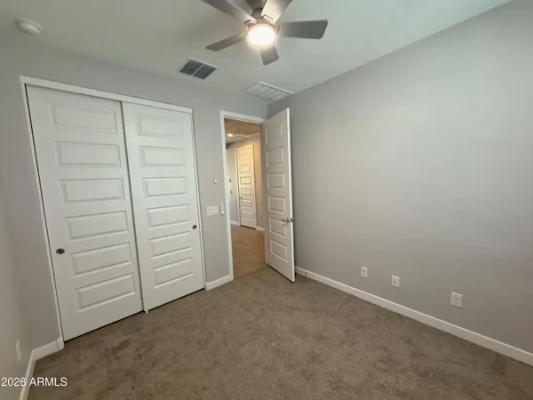 an empty room with closet and fan