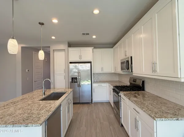 a kitchen with stainless steel appliances granite countertop a sink stove and refrigerator