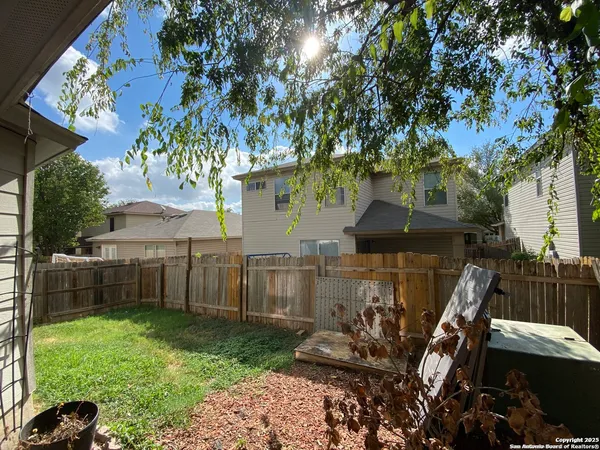 a view of a house with backyard and a tree