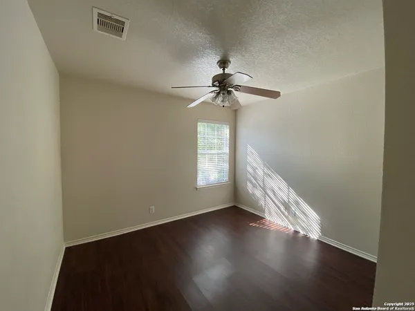 a view of room with window ceiling fan and hardwood floor