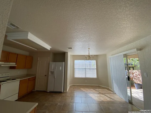 a view of a kitchen with refrigerator and window