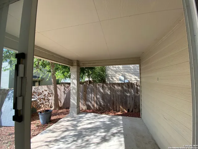 a backyard of a house with large trees and plants