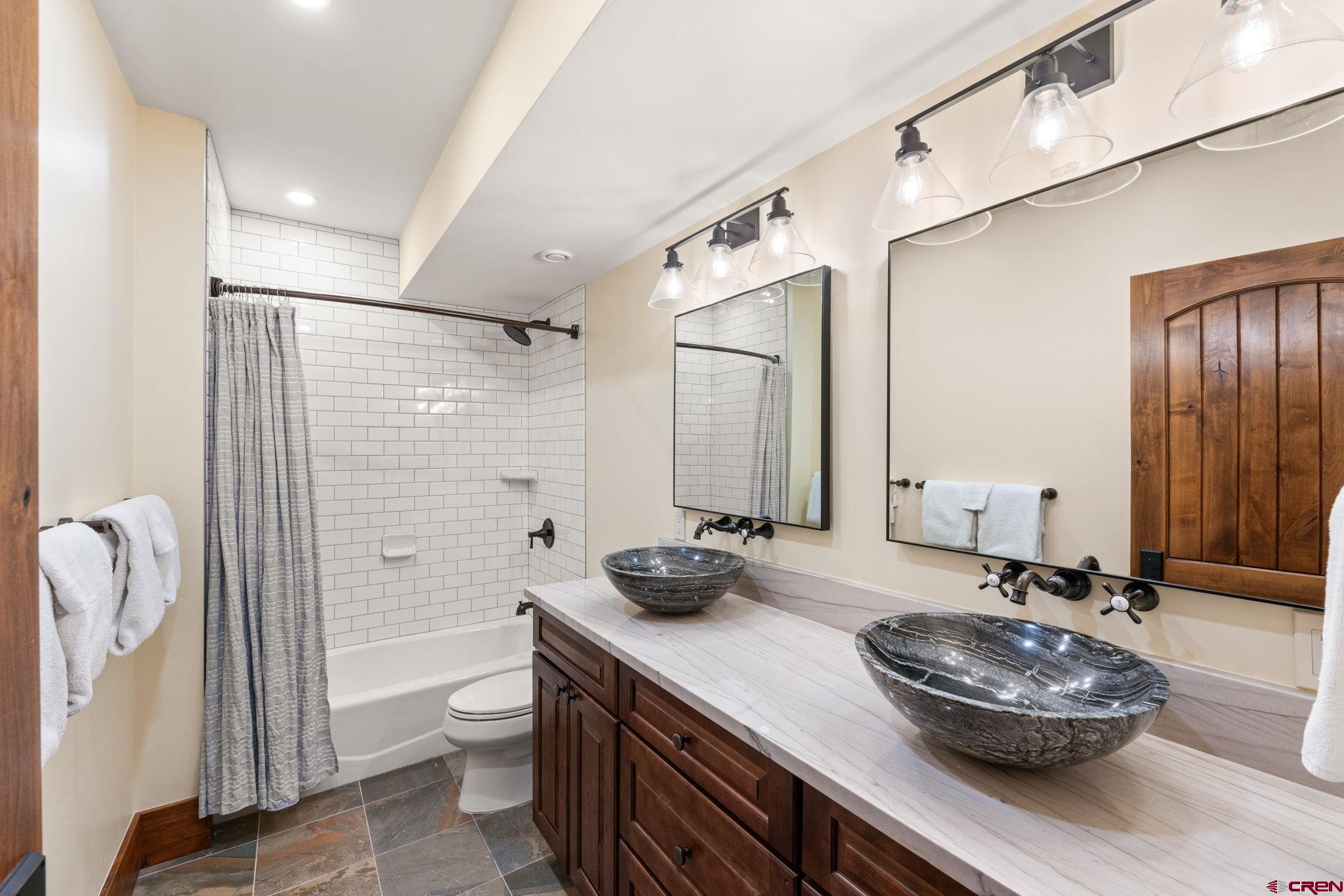 59 Summit Road Crested Butte, CO 81225 - Photo 37 of 45 a bathroom with a granite countertop sink a toilet and shower