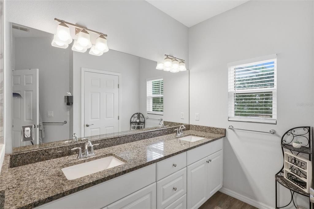 205 Merlot Street DeLand, FL 32724 - Photo 18 of 34 a bathroom with a granite countertop sink a large mirror and a window