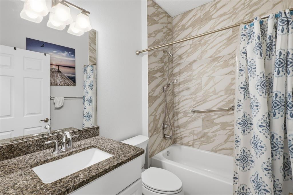 205 Merlot Street DeLand, FL 32724 - Photo 22 of 34 a bathroom with a granite countertop sink toilet and shower