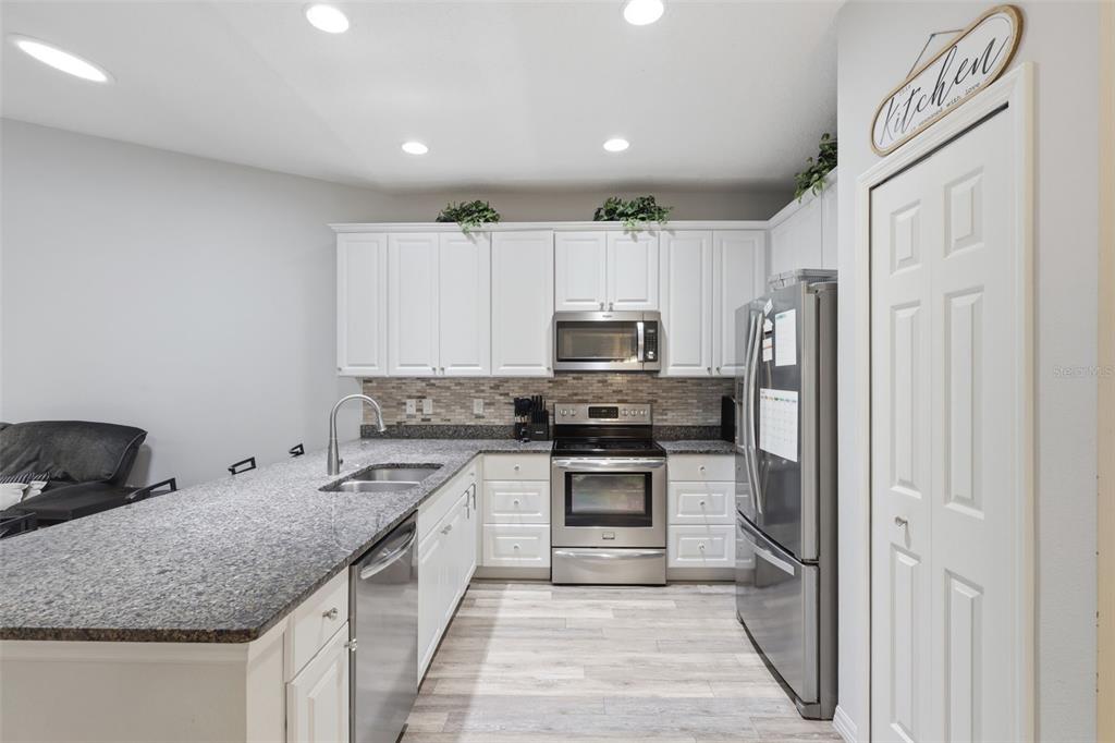 205 Merlot Street DeLand, FL 32724 - Photo 7 of 34 a kitchen with stainless steel appliances granite countertop a sink stove and refrigerator