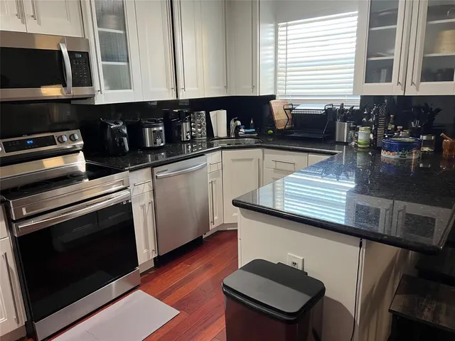 a kitchen with stainless steel appliances a stove a microwave and wooden cabinets