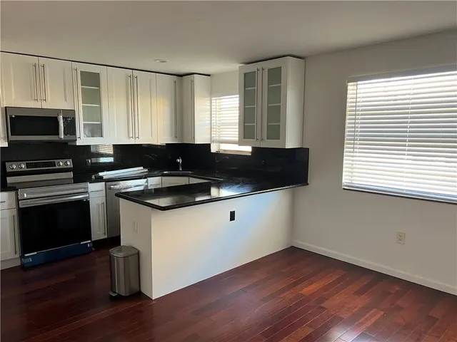 a kitchen with stainless steel appliances granite countertop a refrigerator and a microwave