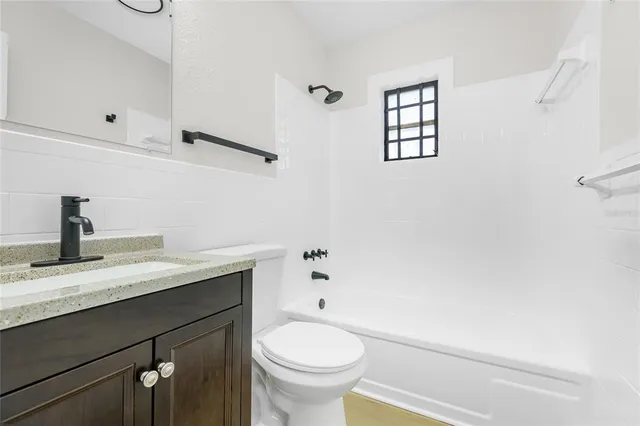a bathroom with a granite countertop sink toilet and a mirror