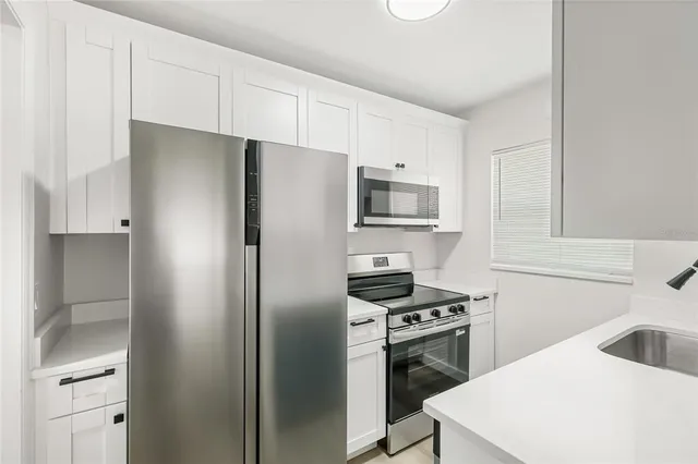 a kitchen with a refrigerator sink and cabinets
