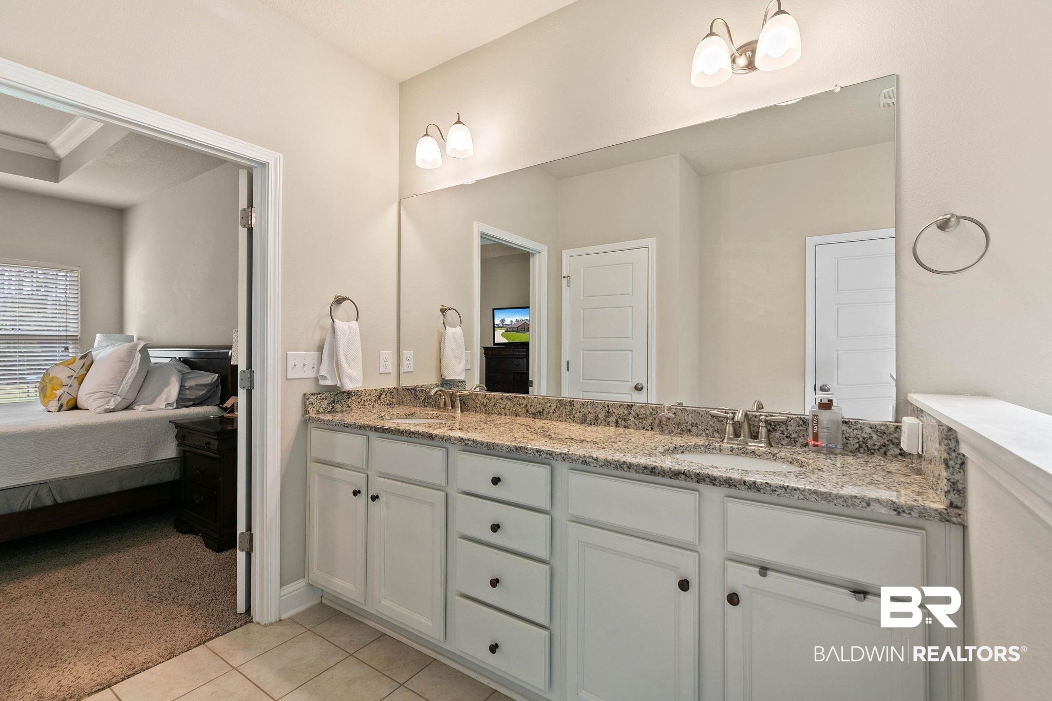 12750 B Jenkins Pit Road Daphne, AL 36527 - Photo 36 of 89 Ensuite bathroom with double vanity, light carpet, and light tile patterned floors