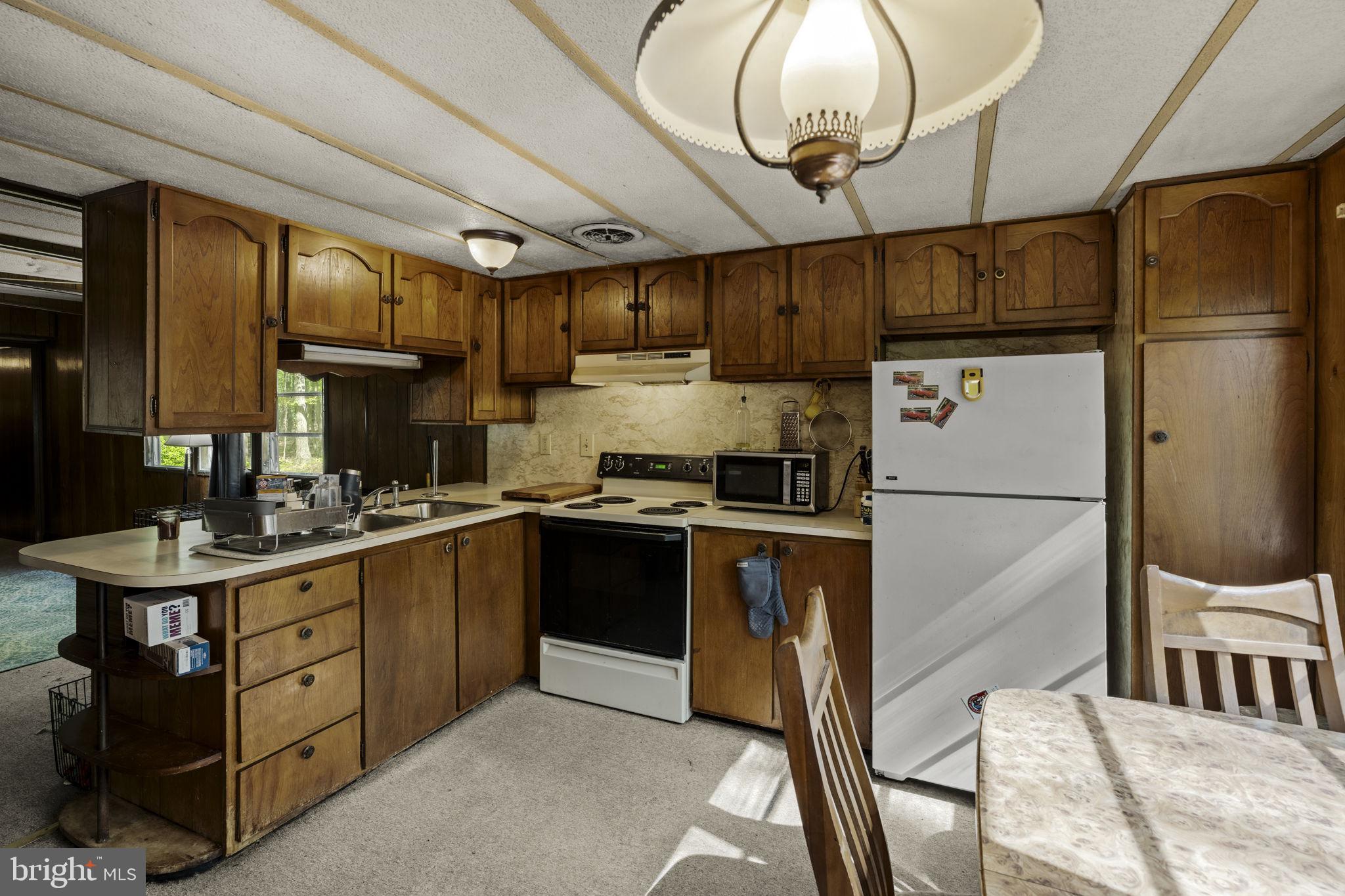1528 Hilltop Road Mohnton, PA 19540 - Photo 11 of 19 a kitchen with stainless steel appliances granite countertop a sink a stove a refrigerator cabinets and chairs