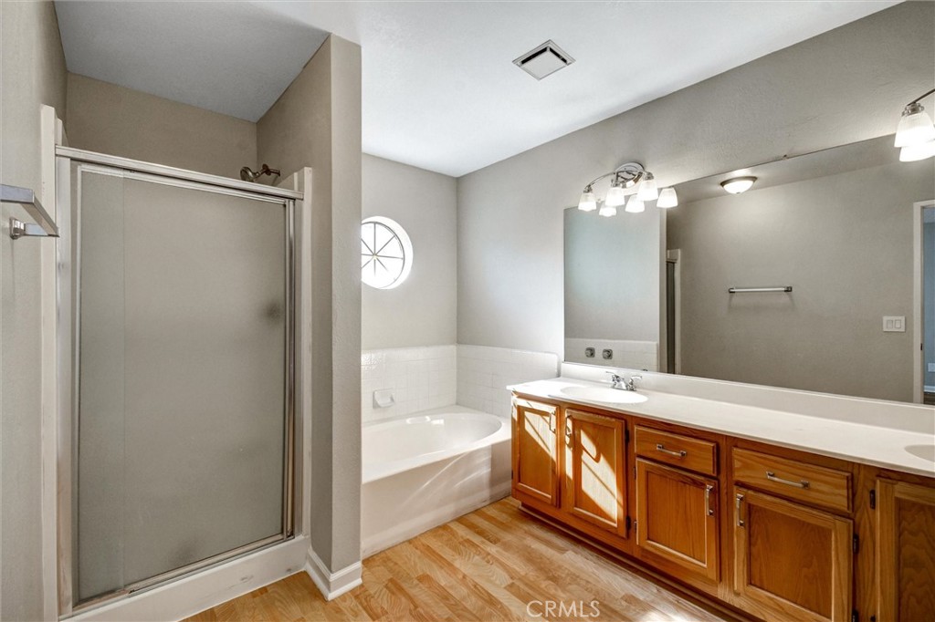 11024 Charleston Street Rancho Cucamonga, CA 91701 - Photo 11 of 30 a spacious bathroom with a double vanity sink a mirror and a bathtub