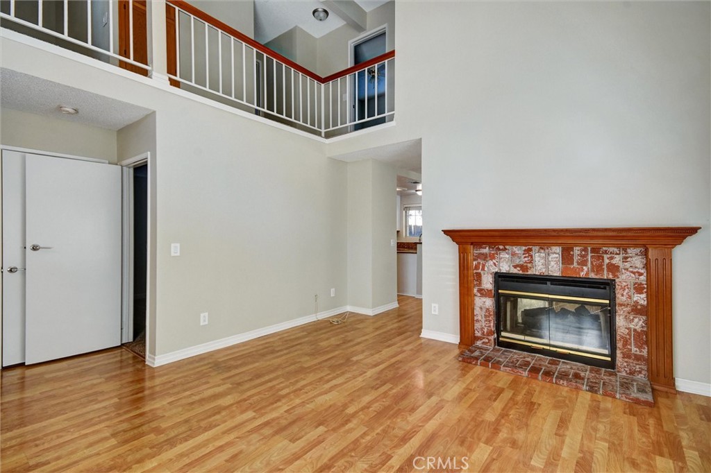 11024 Charleston Street Rancho Cucamonga, CA 91701 - Photo 20 of 30 a view of an empty room with wooden floor a fireplace and a window