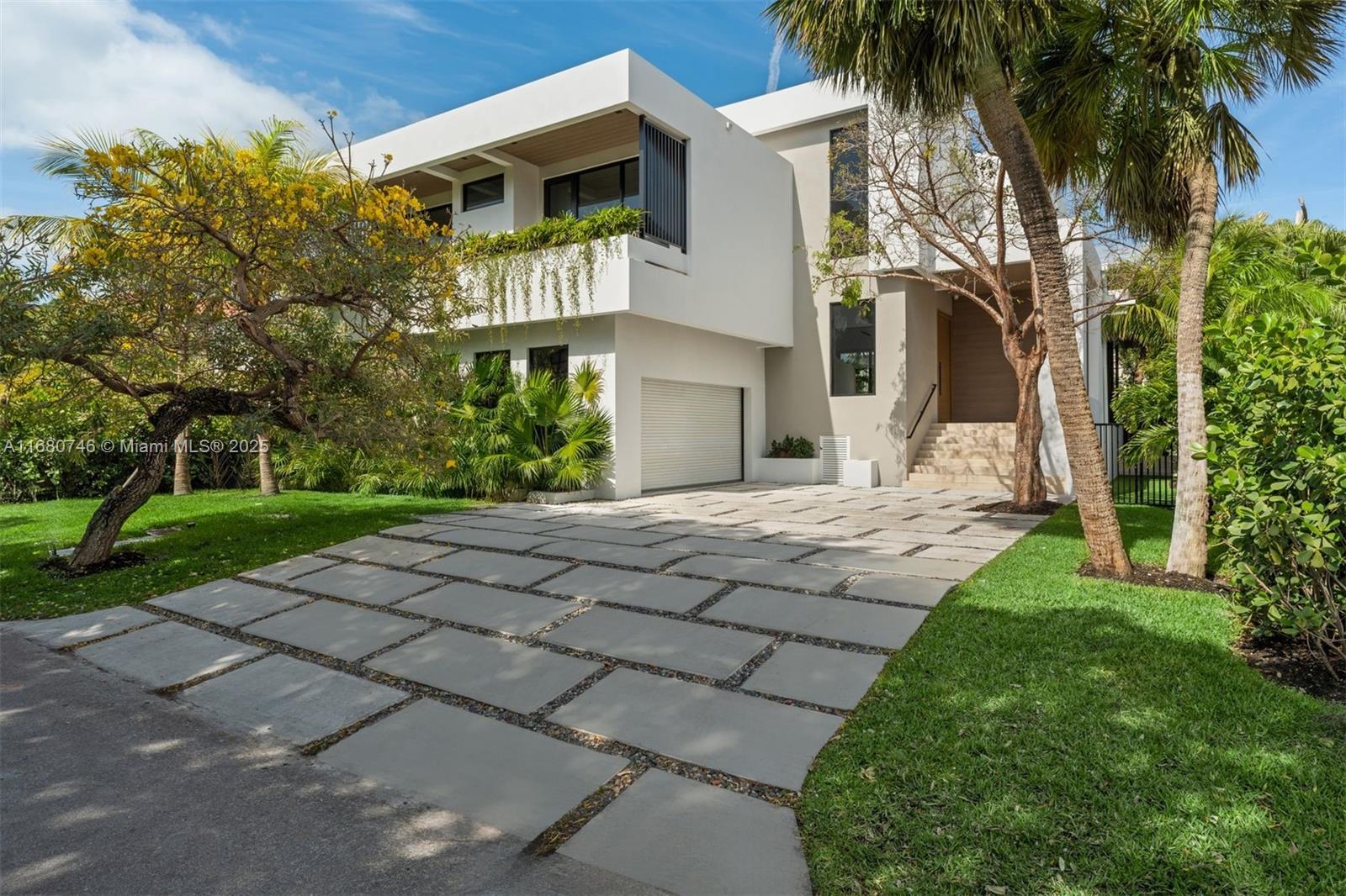 650 Warren Lane Key Biscayne, FL 33149 - Photo 1 of 34 a front view of a house with a yard and potted plants