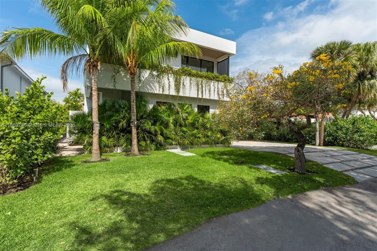 650 Warren Lane Key Biscayne, FL 33149 - Photo 3 of 34 a view of a house with a yard and palm trees
