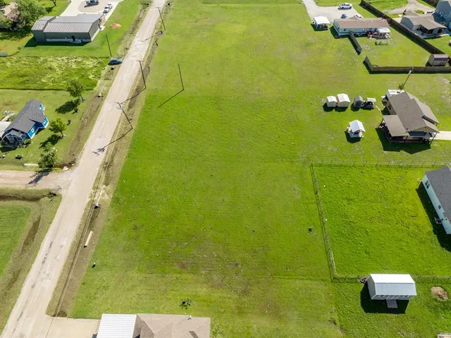 an aerial view of residential houses with outdoor space and trees